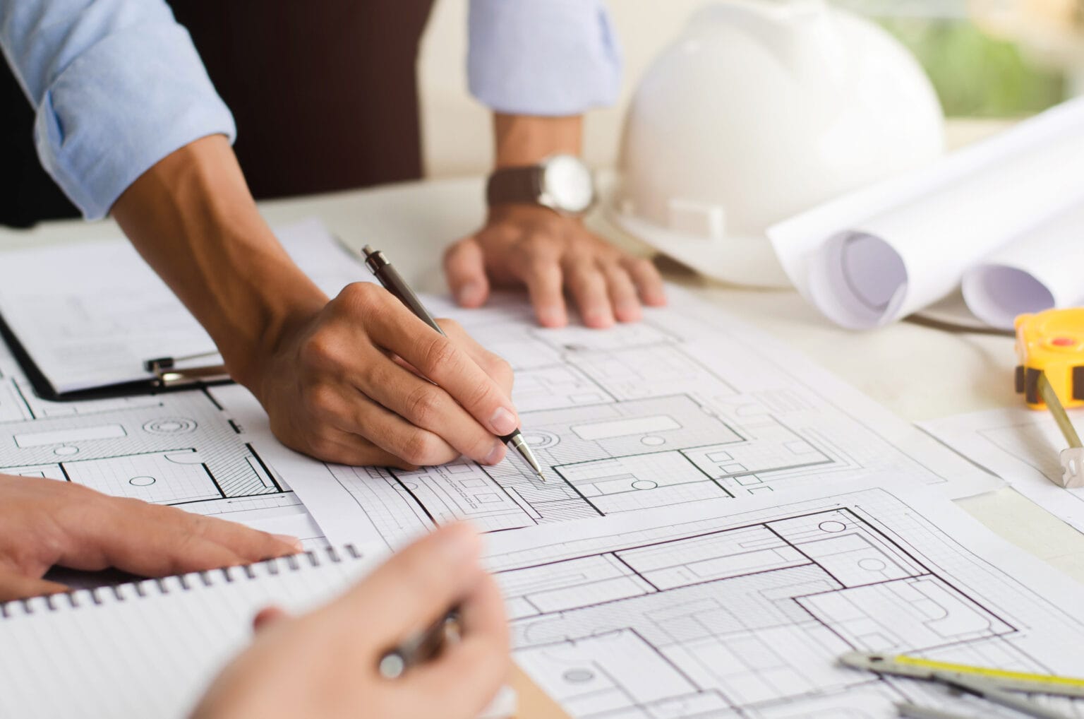 Close up of an engineer planning a hand drawn design. with architect equipment architects talking at the table teamwork and workflow concepts
